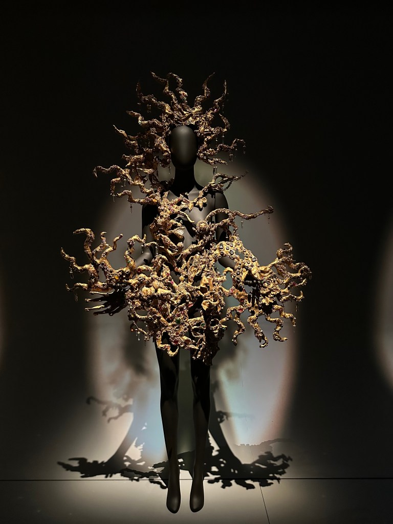 Schiaparelli gold sculptural headpiece and dress.
